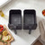 Dual black air fryer baskets on kitchen counter, shown empty from above