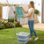 Foldable blue and white laundry basket in use by rotary washing line outdoors