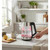Glass electric kettle steaming on kitchen counter, shown with mug and sliced lemon
