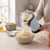 Electric popcorn maker pouring fresh popcorn into bowl in kitchen