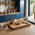 Wooden chopping board with sliced rustic bread, knife and herbs on kitchen counter
