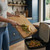 Person scraping fruit peelings from wooden chopping board into kitchen bin