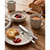 Breakfast set with porridge, berries, tea, crumpet with butter and jam on wooden table