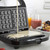 Waffle maker with batter being poured onto plates, ready for cooking