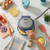 Omelette maker in use with chopped onions, cheese, eggs and seasoning visible nearby