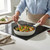 Cream ceramic frying pan cooking colourful vegetables and chicken on induction hob