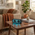 Portable Bluetooth speaker with blue lights on coffee table in cosy living room