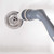 Grey handheld drain cleaner rinsing kitchen sink plughole