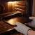 Black oven tray being placed in oven by person wearing grey oven gloves