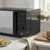 Black microwave oven on kitchen worktop, front view, product listing image