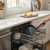 Black non-stick frying pan being loaded into dishwasher, shown for easy cleaning feature