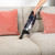 Corded stick vacuum cleaner in navy and silver with clear dust container, upright position
