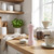 Light pink salt mill on kitchen worktop near bowl of salt, coffee jar, and cup