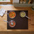 Induction hob with three silver saucepans cooking colourful vegetables and rice