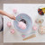 Cotton candy machine in use with pink candy floss, marshmallows, and fruits on table