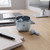 Light blue wireless earbuds with charging case on a desk