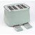 Sage green 4-slice toaster with two open crumb trays, shown from a side angle