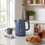 Blue electric kettle on kitchen counter with mug, croissants, and coffee