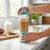Green portable blender mixing iced coffee on kitchen counter