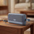 Blue portable wireless speaker on wooden table in lounge setting