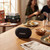 Black portable Bluetooth speaker on table at a casual gathering