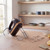 Black hand mixer with wood accents and four stainless steel attachments on kitchen counter