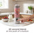 Personal blender with berry smoothie, finger pressing start button, in modern kitchen