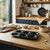 Black non-stick 6-cup muffin tray on kitchen worktop, shown from above.