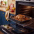 Roasting tray with whole roast chicken and vegetables in oven