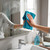 Hand cleaning bathroom mirror with blue microfibre cloth