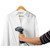 Handheld garment steamer in use on a white shirt on hanger