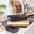 Black roasting tin with rack and matching loaf tin on kitchen counter