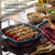 Green grill pan on hob with chicken and vegetable skewers, highlighting even cooking