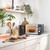 Black microwave on kitchen worktop with door open and glass bowl inside