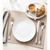 Table setting with silver cutlery, white plate, napkin and coffee with croissant.