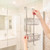 Chrome two-tier shower caddy hanging over glass shower screen