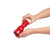 Red pepper mill held in hands, showing size and shape.