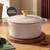 Cream cast iron casserole dish with gold handle, shown on wooden board, lifetime guarantee badge