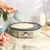 Mint green electric crepe maker on worktop, batter being poured, eggs and ingredients nearby