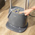 Grey upright garment steamer with digital controls, shown with hand pressing power button