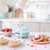 Pastel blue mini waffle maker on kitchen counter with waffles and fruit