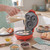 Red mini doughnut maker with batter being poured into three moulds