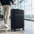 Black large suitcase with blue trim and spinner wheels in an airport