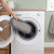 Grey chenille mop head being placed in washing machine