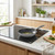 Grey non-stick frying pan with oil on induction hob in modern kitchen