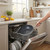 Non-stick grey frying pan placed in dishwasher, shown in modern kitchen