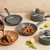 Set of grey non-stick saucepans and frying pans, lifestyle kitchen display