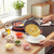 Grey non-stick frying pan flipping omelette over plate on hob