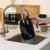 Black electric kettle being filled at kitchen sink, shown from side with lid open