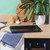 Black non-stick baking tray on kitchen counter with plant and cookbook nearby